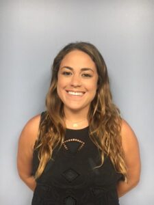 a woman with long hair and black top smiling