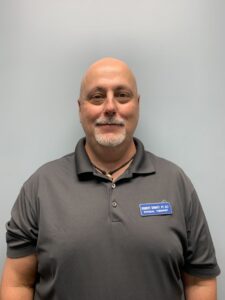 a man with a bald head wearing a gray shirt