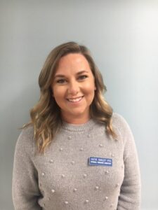 a woman wearing a gray sweater and jeans