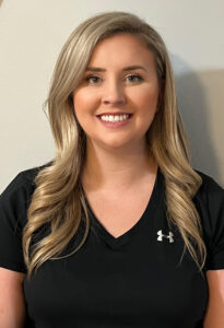 a woman in a black shirt is smiling for the camera