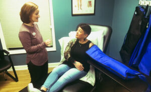two women are talking in a room with blue walls