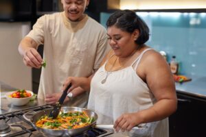 a man and woman preparing food in a kitchen