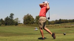 a man swinging a golf club at a ball