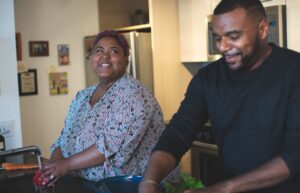 a man and woman preparing food in a kitchen