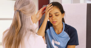 a woman is putting her hands on her head