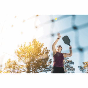 person holding a pickleball paddle on a court