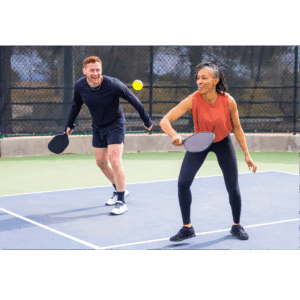 a man and woman playing pickleball on a court