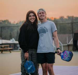 a man and woman standing on a tennis court