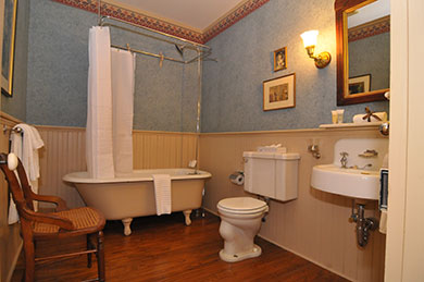The Blue Room Bathroom Atlantic Hotel hotel bathroom with shower tub toilet sink chair mirror on wall with pictures and blue wallpaper