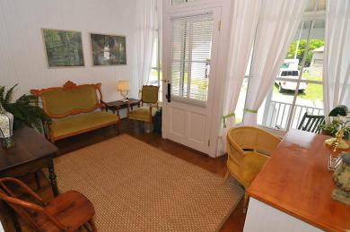 The Gardner’s Cottage Sitting Area and Desk Atlantic Hotel inside entrance of cottage with hardwood floors brown rug wooden desk with chairs