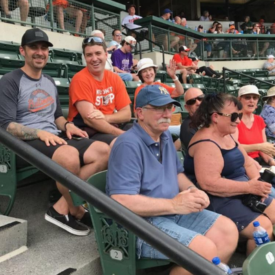 a group of people sitting in the stands at a baseball game