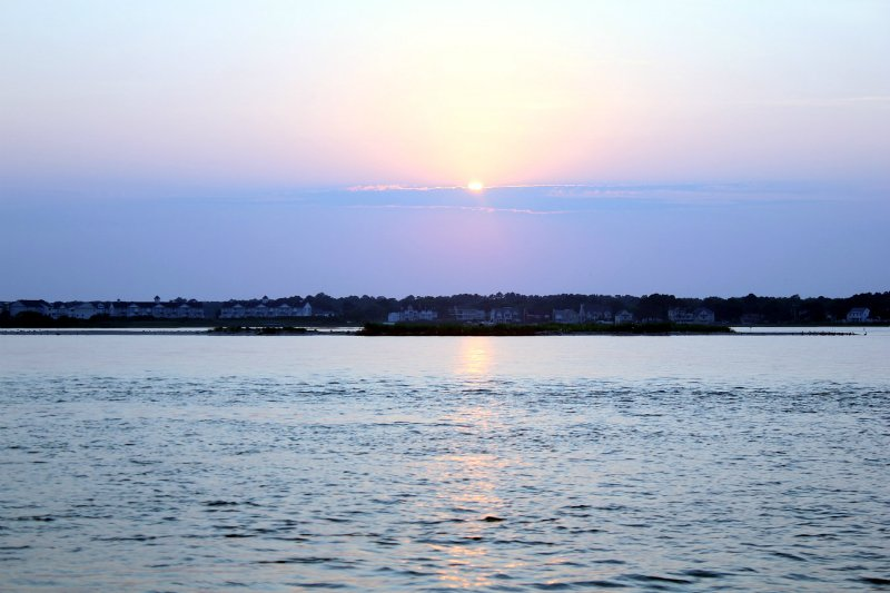 the sun is setting over a body of water