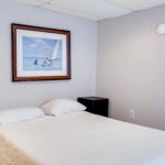 one bed next to closet with picture on wall