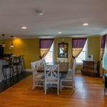 kitchen with bar stools and dining room with table and seating for 8