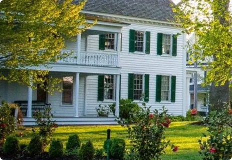a large white house with green shutters