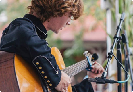 a man with red hair playing a guitar