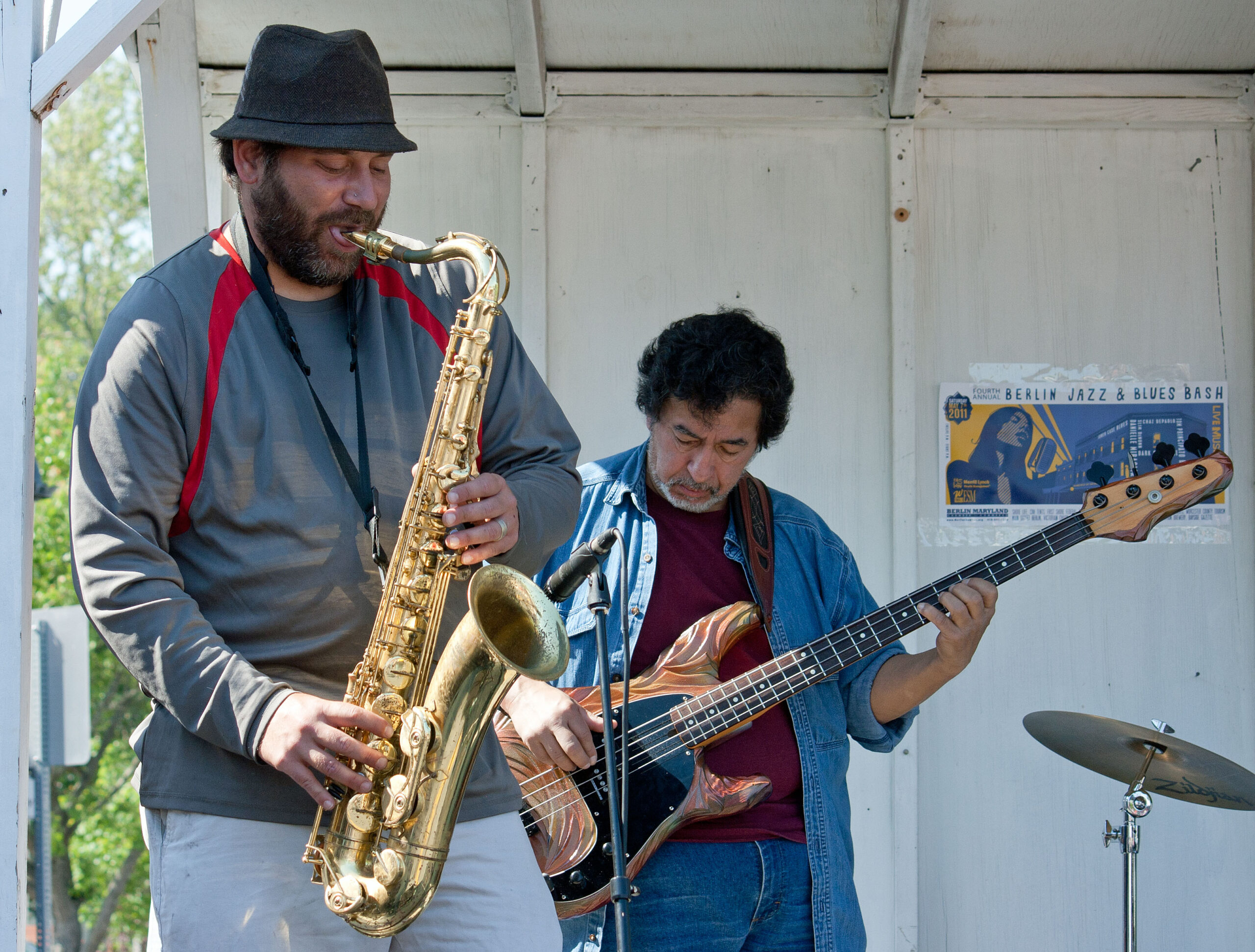 a man standing next to a man playing a saxophone
