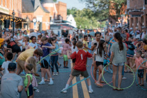 A large group of children hoola hooping in the street