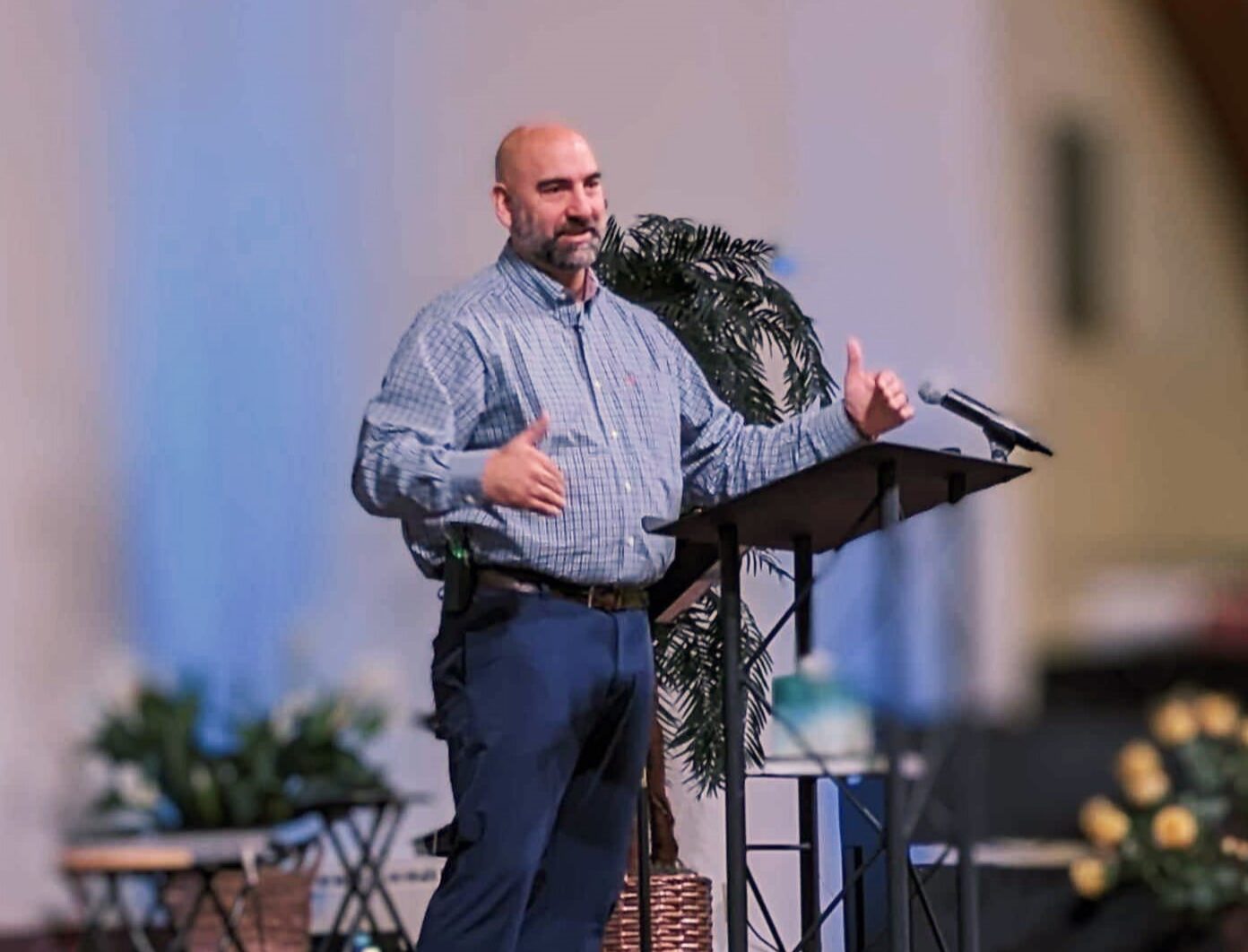 a man standing at a podium presenting a sermon