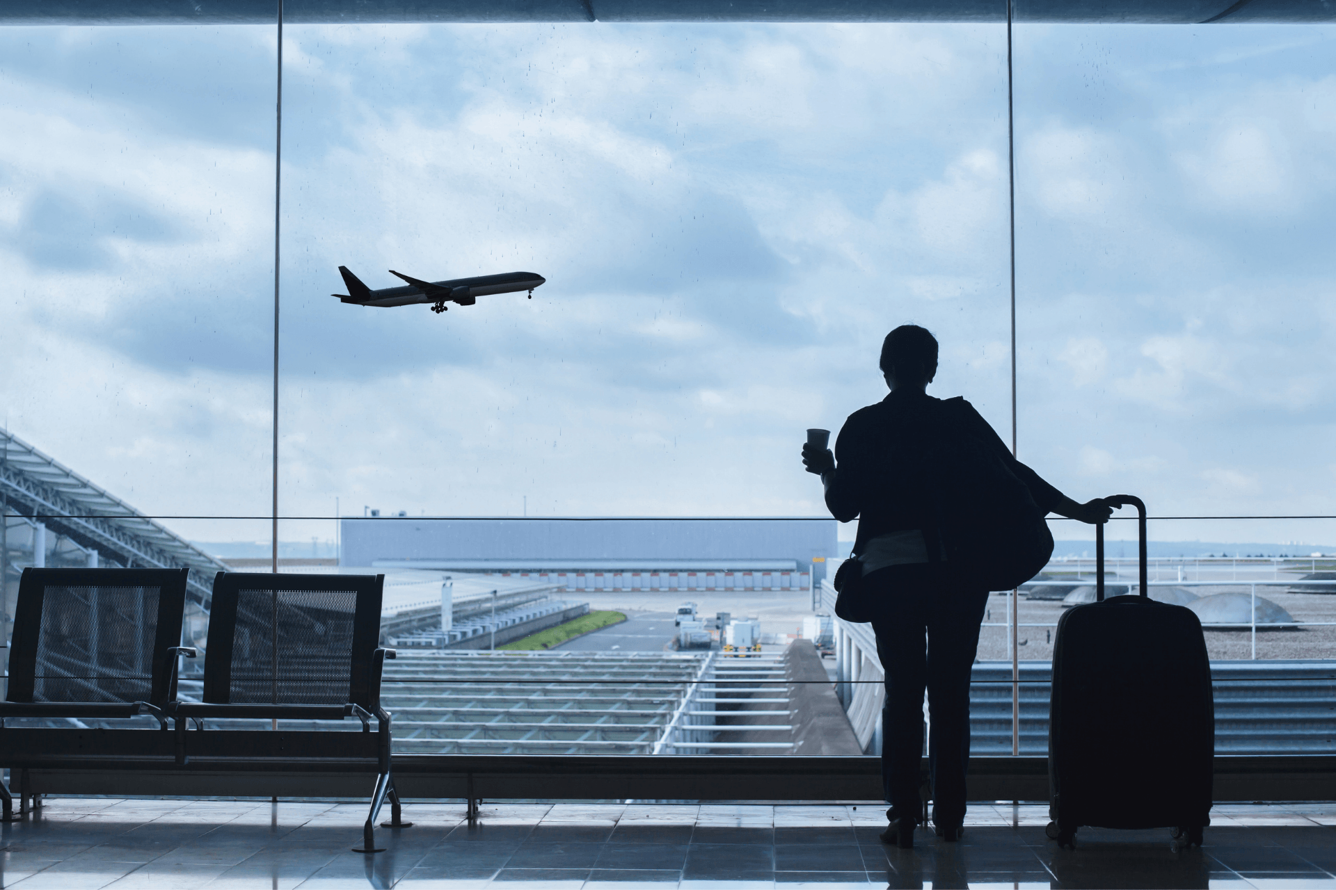 woman standing in an airport and looking outside