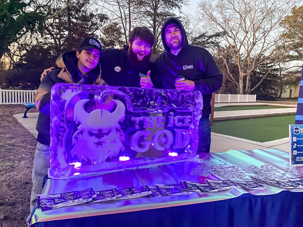 a group of people standing next to a purple sign