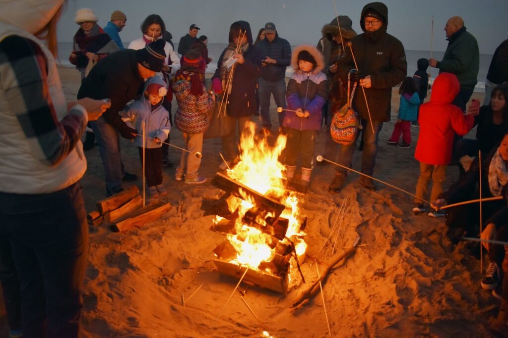 a group of people standing around a fire pit