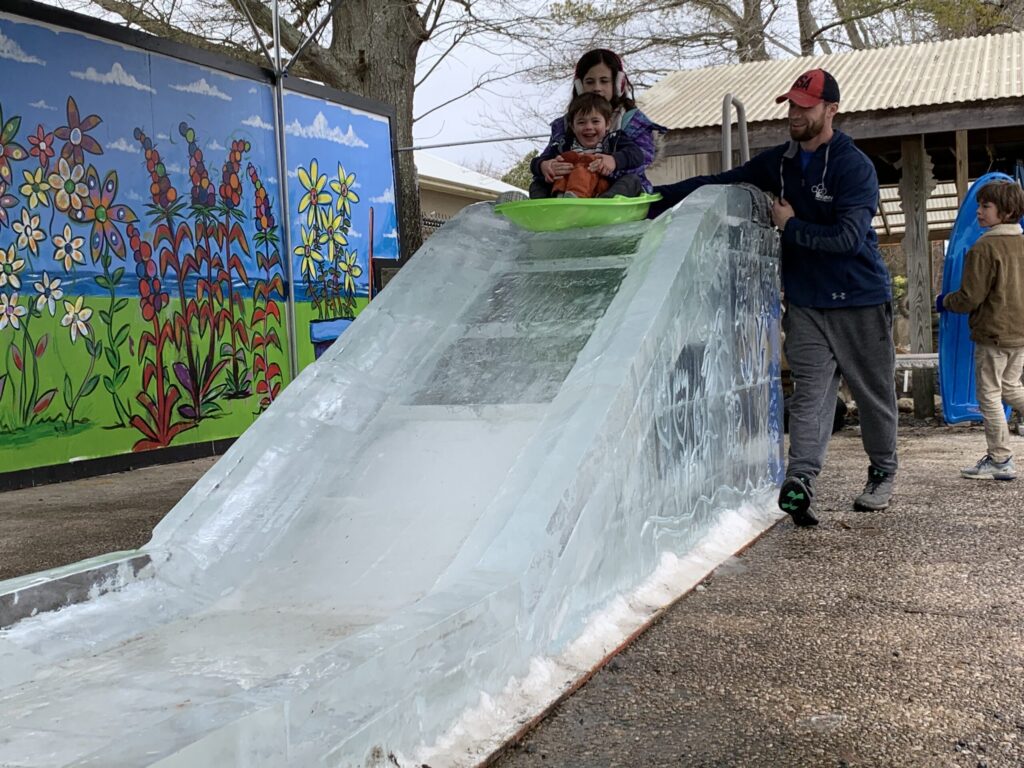 a group of people standing next to a slide