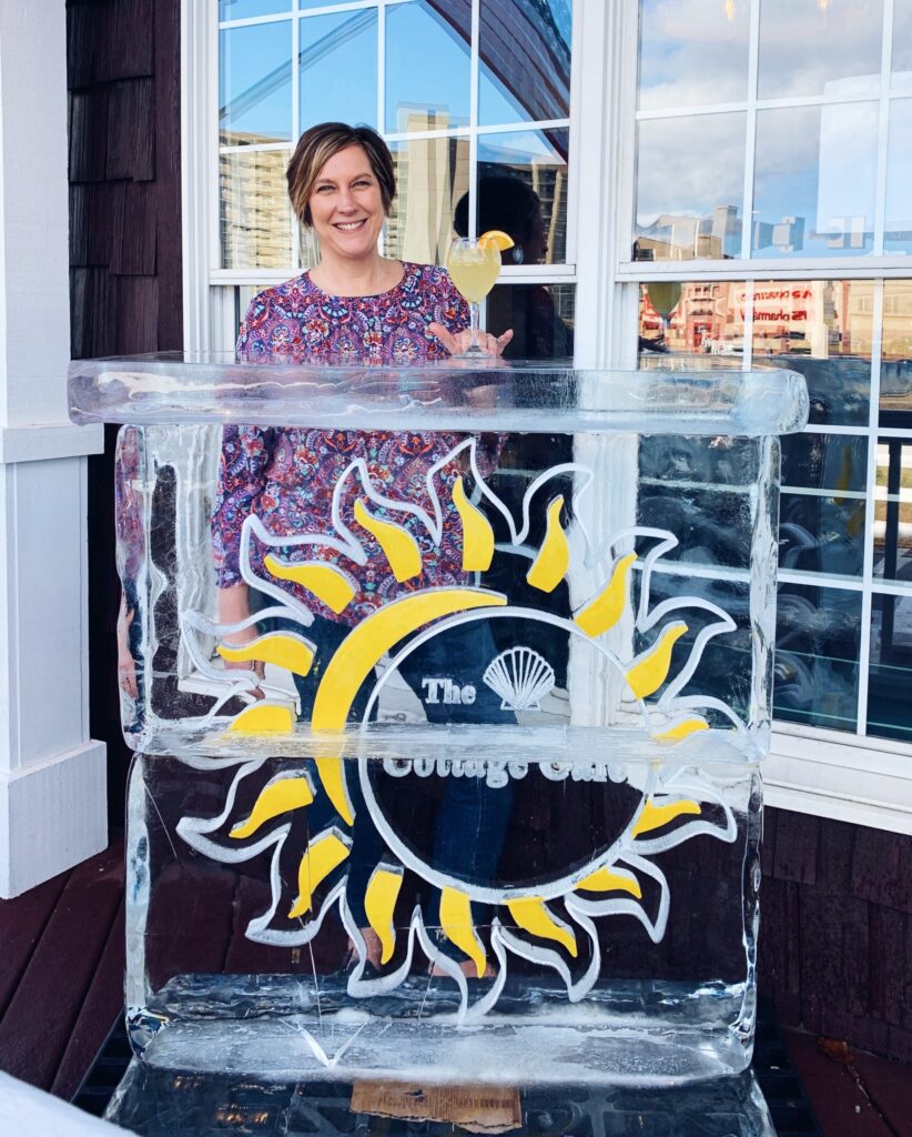 a woman standing in front of a sun ice sculpture