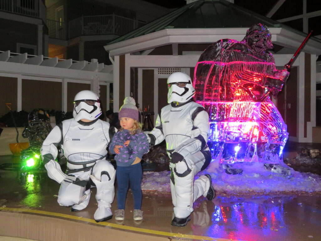 a group of people in costumes standing in front of a fountain