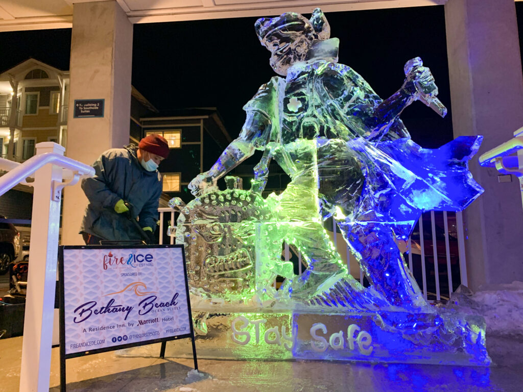 a man standing next to a statue of a skeleton