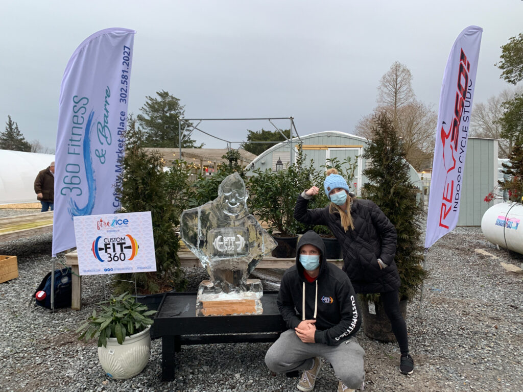 a couple of people standing next to a statue