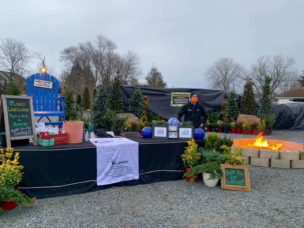 a table with a sign on it in front of a fire pit