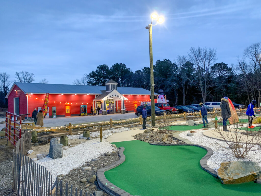 a miniature golf course with a red building in the background