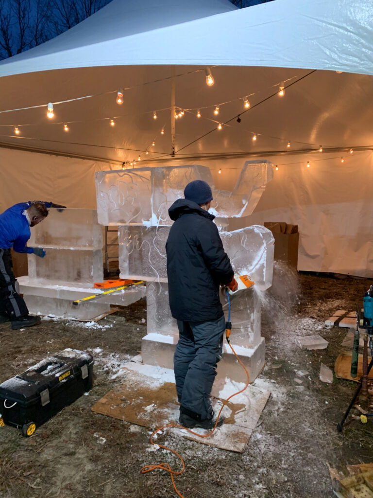 a group of people standing around a white tent