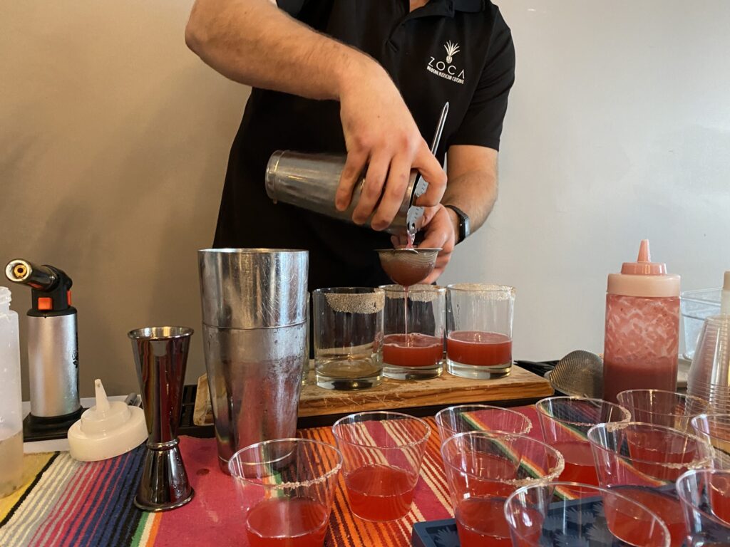 a man pours a drink from a shaker
