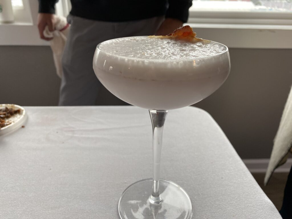 a person standing next to a table with a drink in it