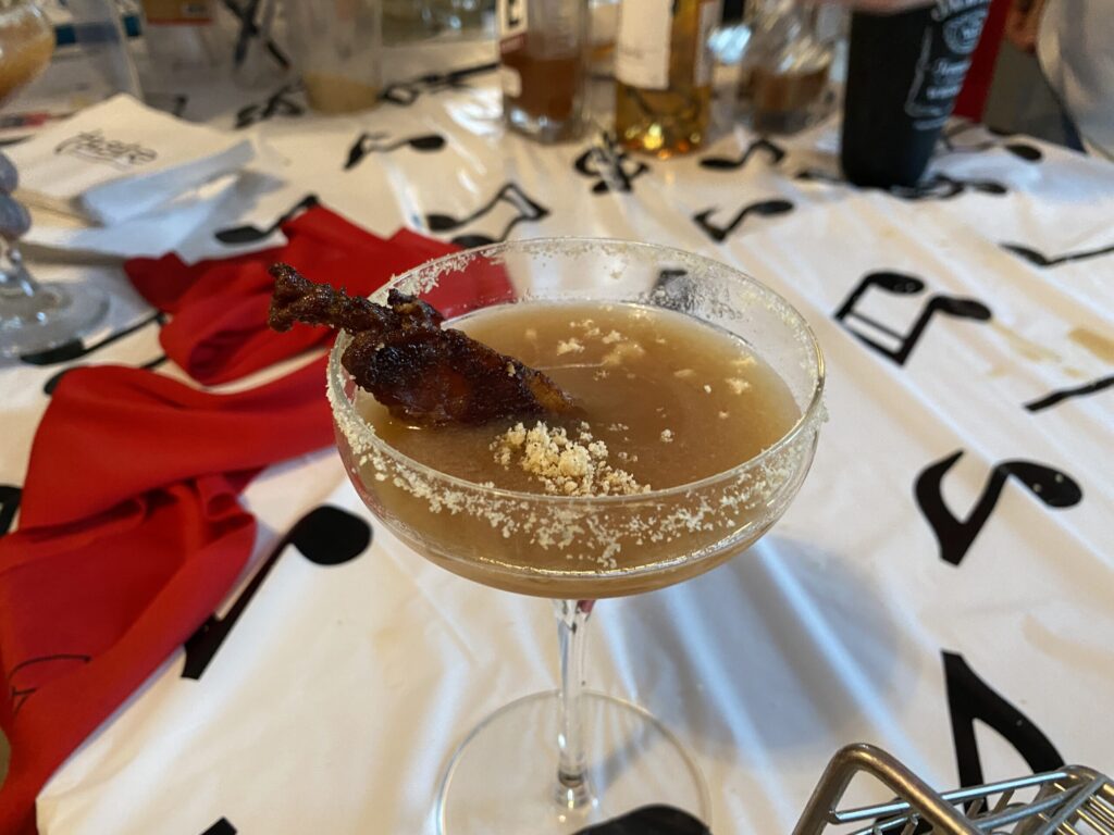 a glass of alcohol sitting on top of a table