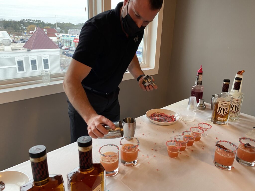 a man standing in front of a table filled with drinks