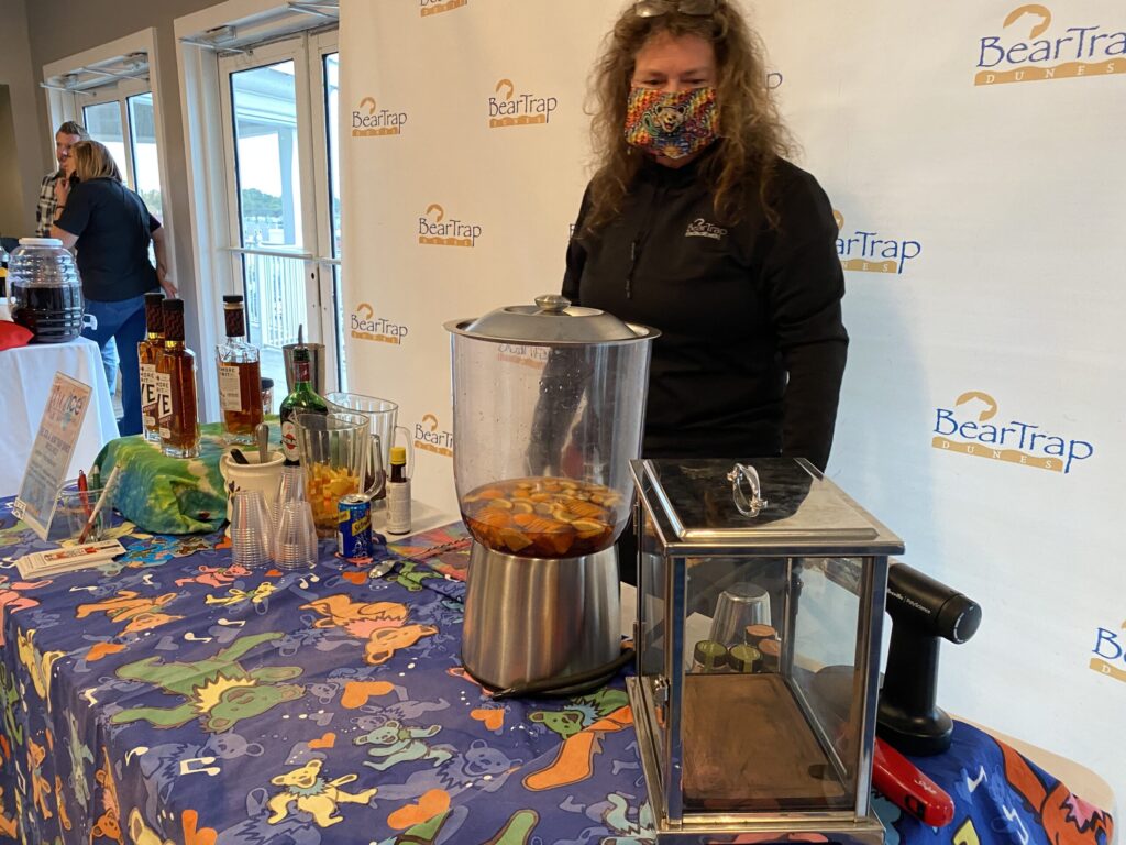 a woman is standing behind a table with food on it