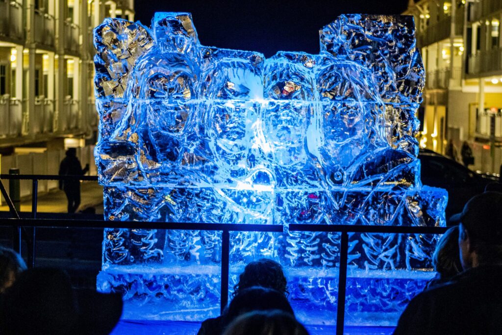a group of people standing in front of an ice sculpture