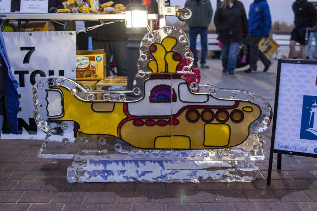 a yellow submarine shaped ice sculpture sitting on top of a sidewalk