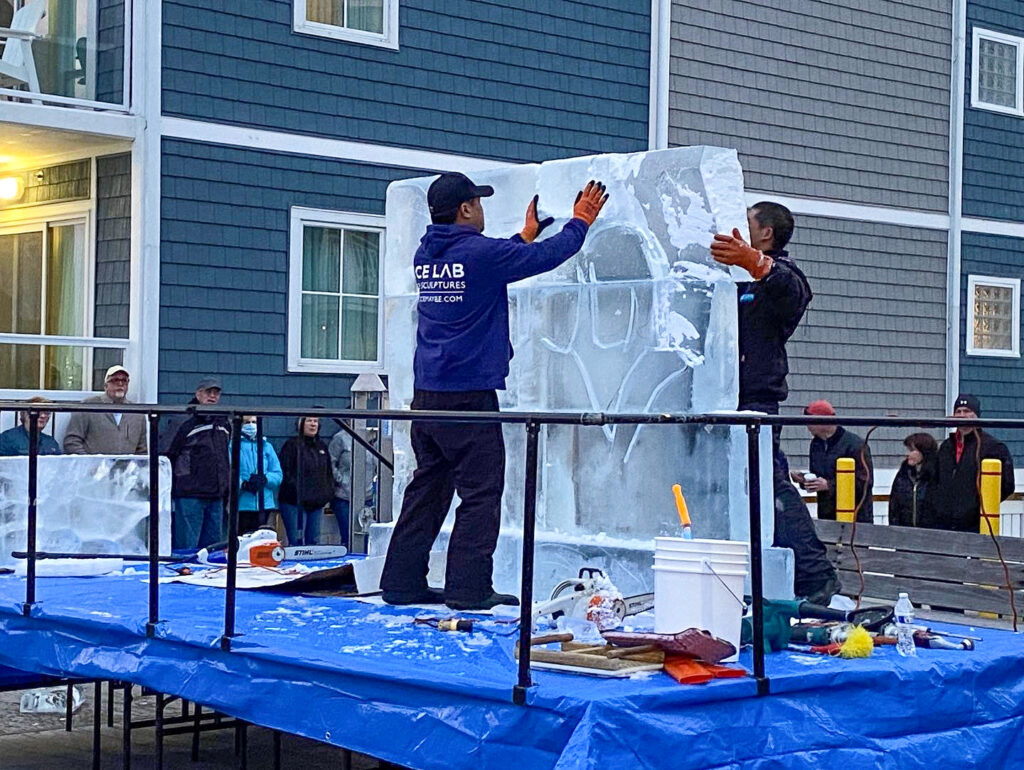 a group of people standing on top of a blue table