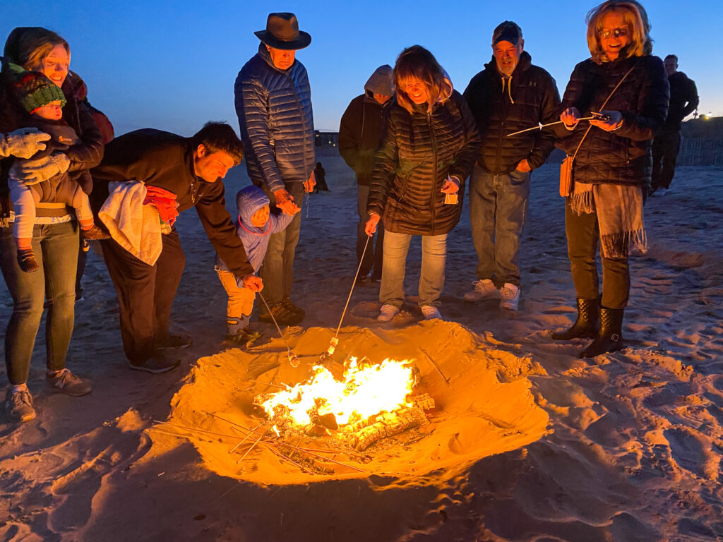 a group of people standing around a fire pit