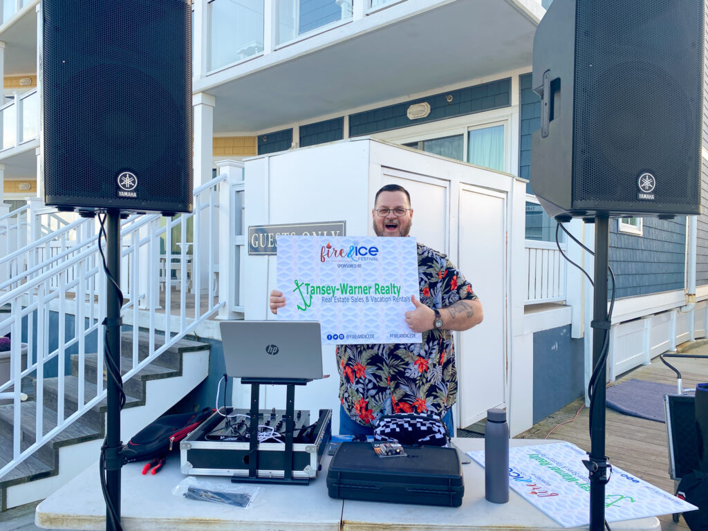 a man holding a sign in front of some speakers