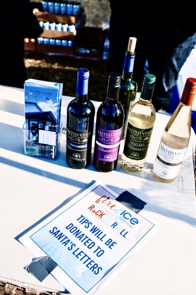 a table topped with bottles of wine and a sign