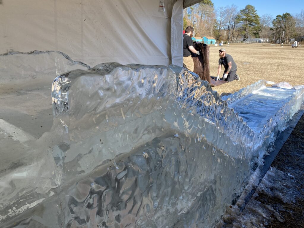 two men working on an ice sculpture in a field
