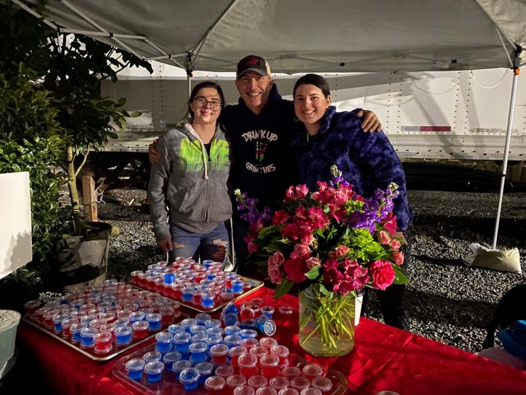 a group of people standing next to a table full of drinks