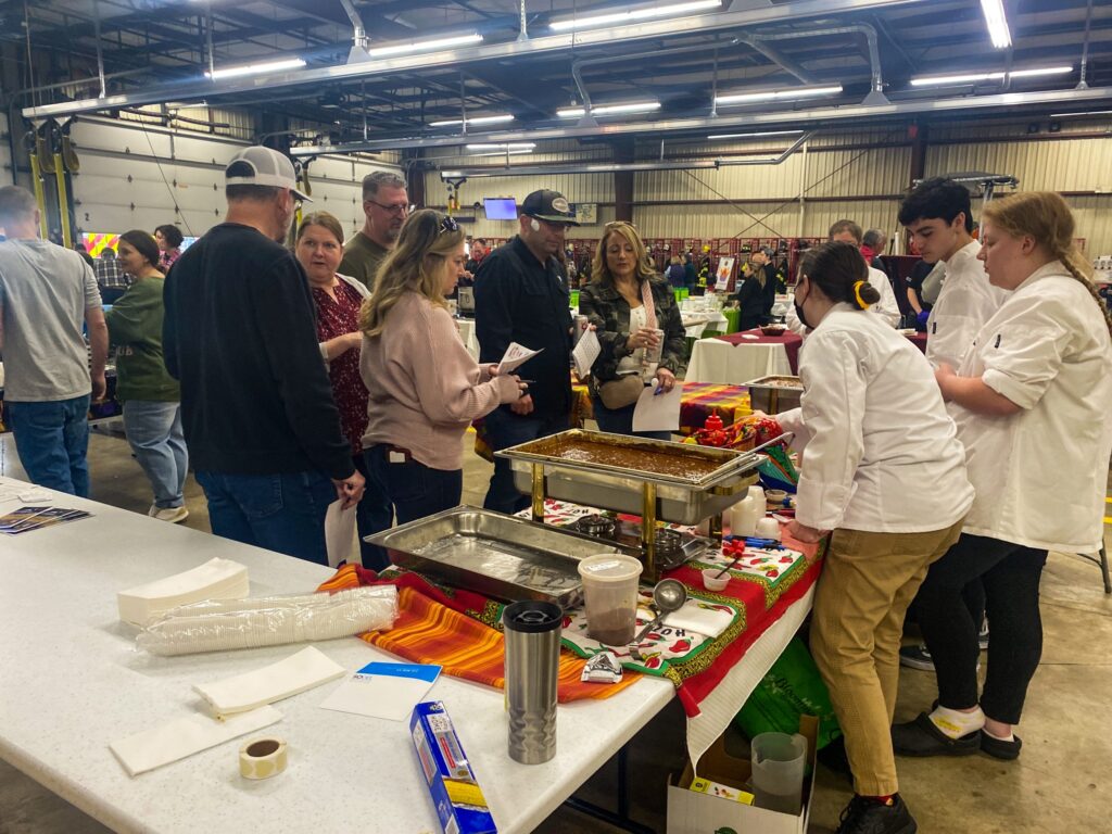 a group of people standing around a table