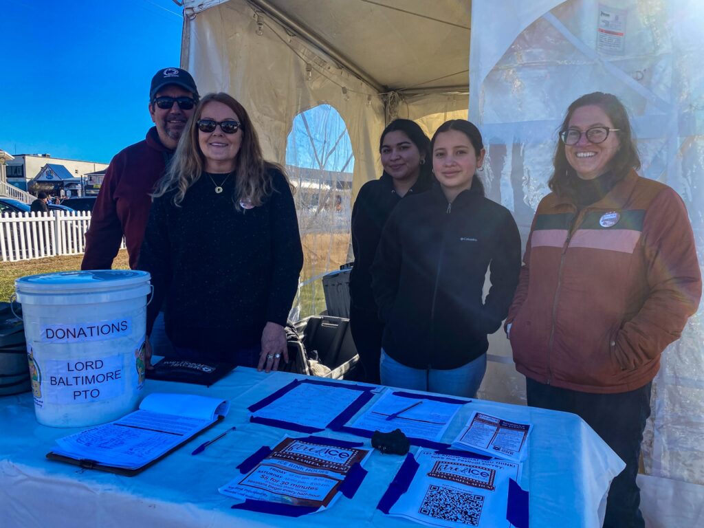a group of people standing in front of a table
