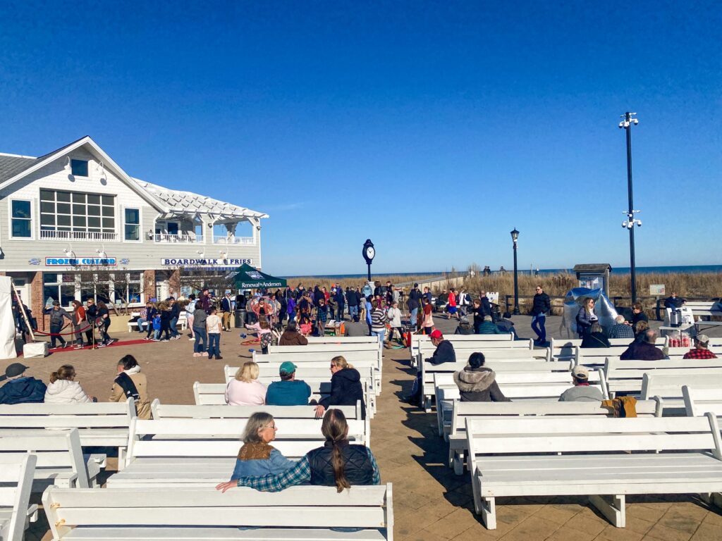 a group of people sitting on top of white benches